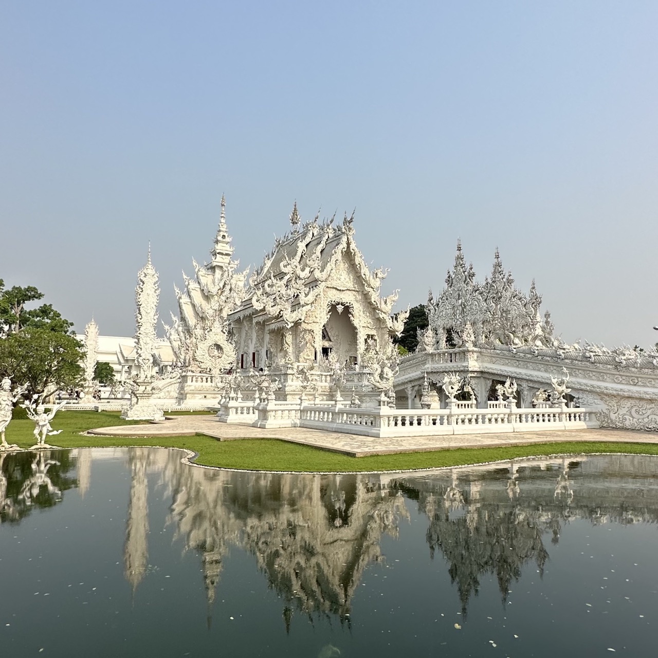 Tempio bianco di Chiang Rai, si specchia nel laghetto che lo circonda.